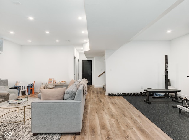 living room featuring light wood-type flooring, stairs, baseboards, and recessed lighting