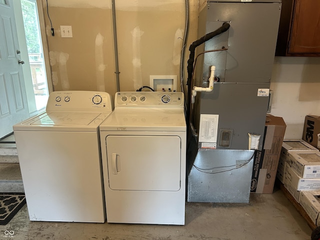 clothes washing area featuring laundry area, washing machine and dryer, and a healthy amount of sunlight