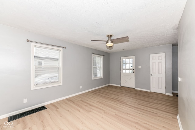 unfurnished room with ceiling fan, light hardwood / wood-style floors, and a textured ceiling