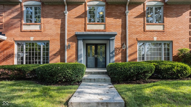 entrance to property featuring french doors and brick siding