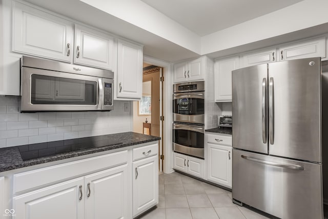 kitchen with tasteful backsplash, appliances with stainless steel finishes, white cabinets, and light tile patterned flooring