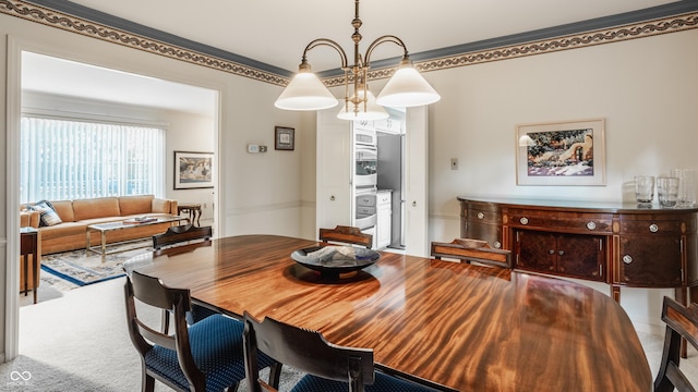 dining room featuring an inviting chandelier and carpet flooring