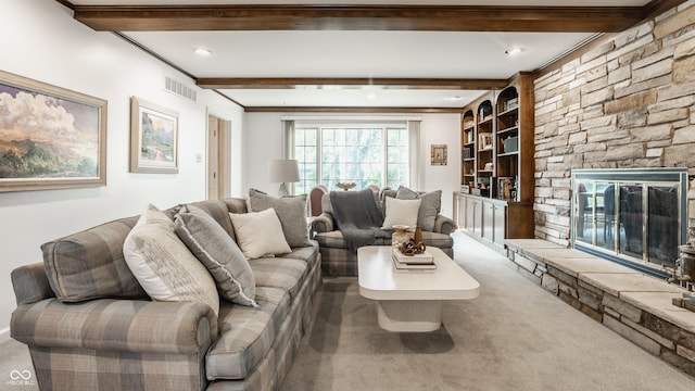 living area with beam ceiling, visible vents, and a fireplace