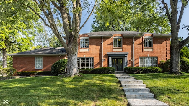 view of front of house with brick siding and a front lawn