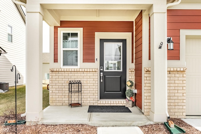 property entrance featuring central AC and brick siding