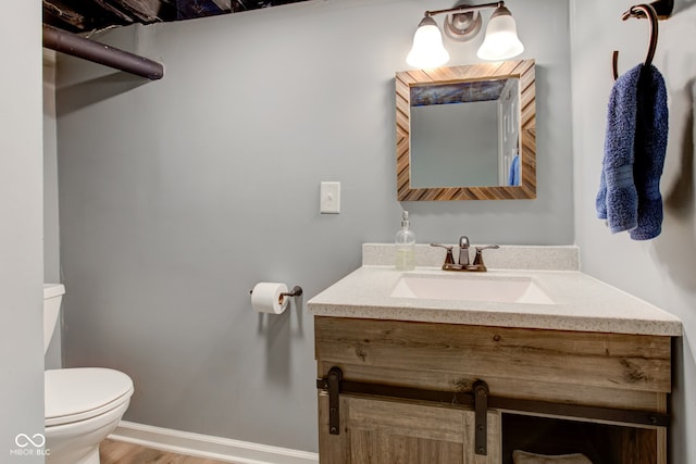 bathroom with vanity, hardwood / wood-style floors, and toilet