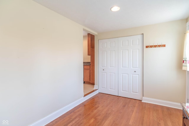 unfurnished bedroom with a closet and light wood-type flooring