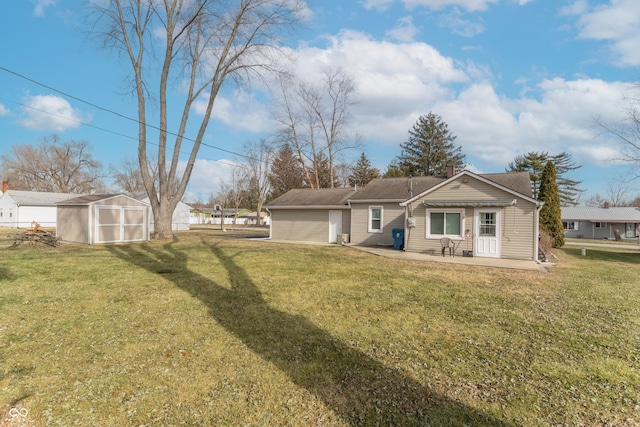 rear view of property featuring a storage shed, a yard, and a patio