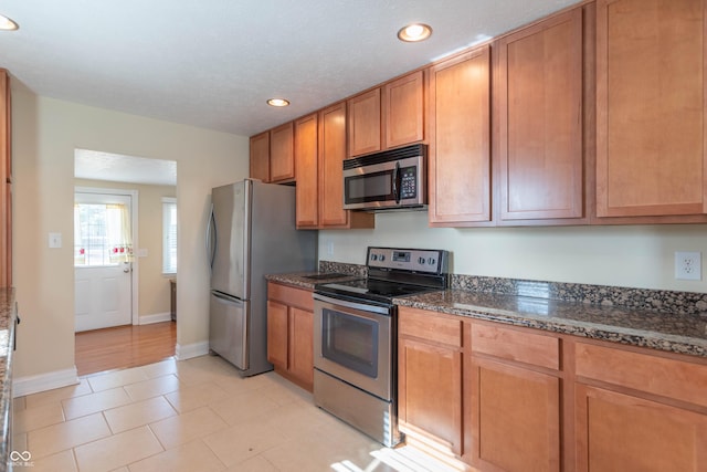 kitchen featuring dark stone countertops and appliances with stainless steel finishes