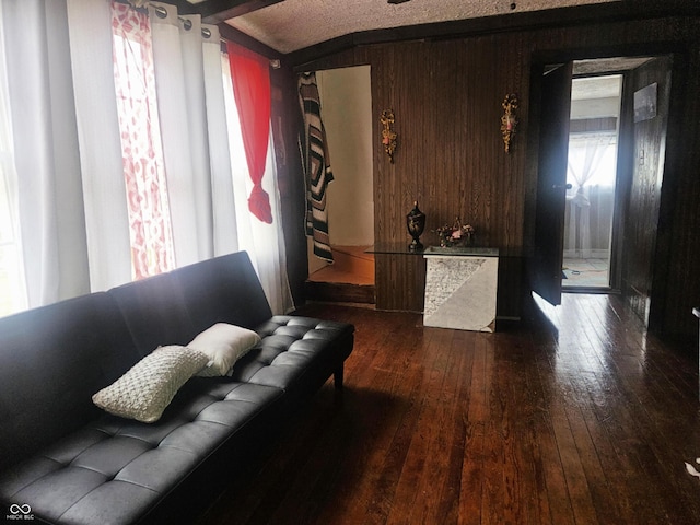 living room featuring dark wood-type flooring and wooden walls