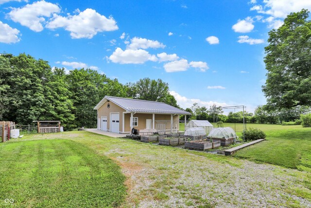 800 N 400 W, Bargersville, IN 46106 - view of front of home with a garden, an outdoor structure, a front lawn, a detached garage, and a metal roof