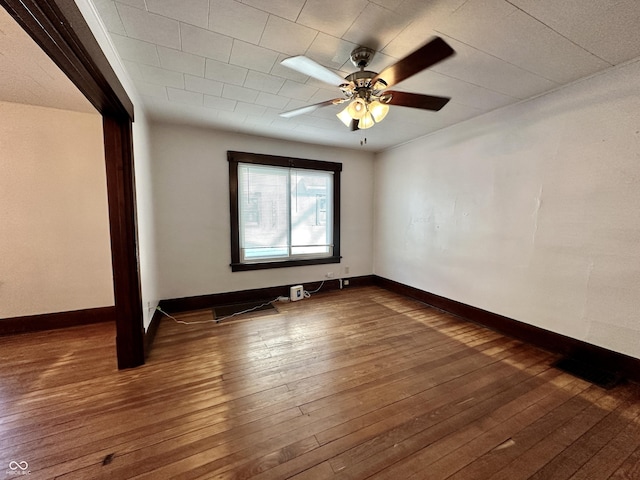 empty room with dark wood-type flooring and ceiling fan