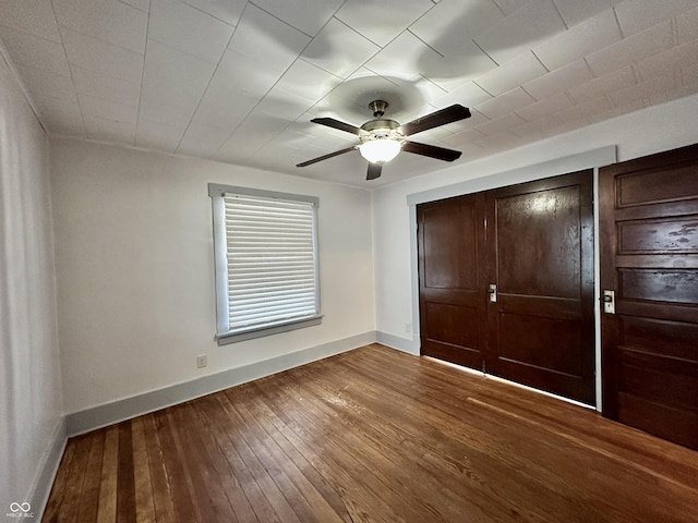 unfurnished bedroom with wood-type flooring, ceiling fan, and a closet