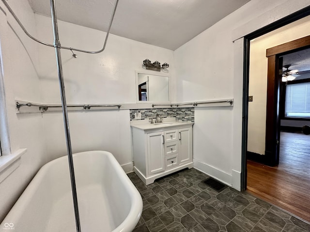 bathroom featuring vanity, a bathtub, and decorative backsplash