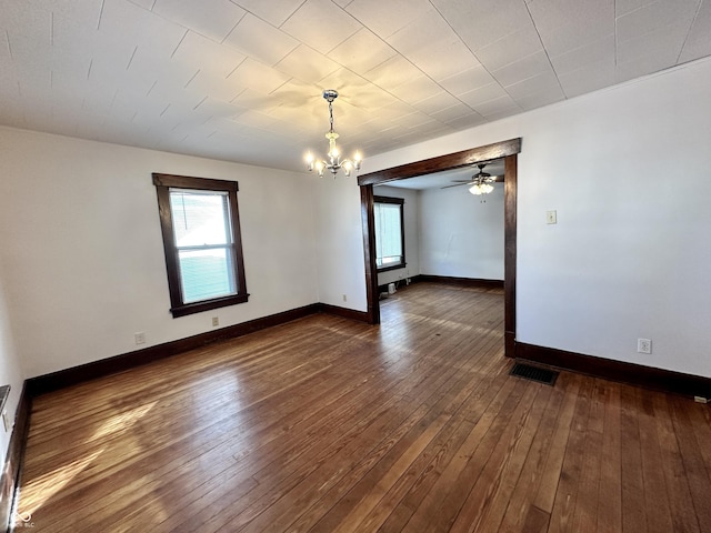 empty room featuring a notable chandelier and dark hardwood / wood-style floors