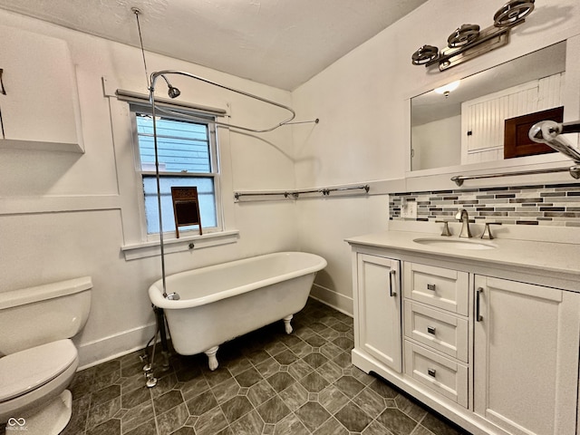 bathroom featuring backsplash, vanity, toilet, and a tub