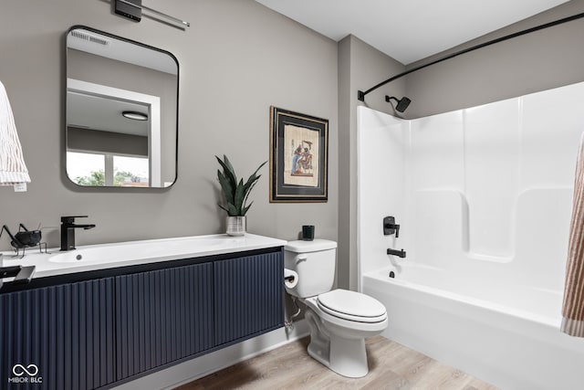 full bathroom with bathtub / shower combination, wood-type flooring, toilet, and vanity