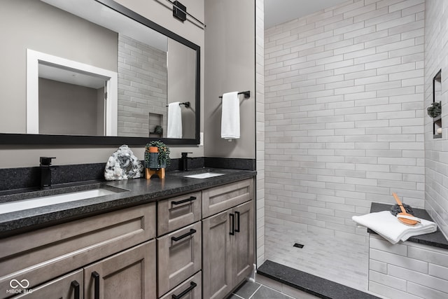 bathroom with vanity, tile patterned flooring, and tiled shower