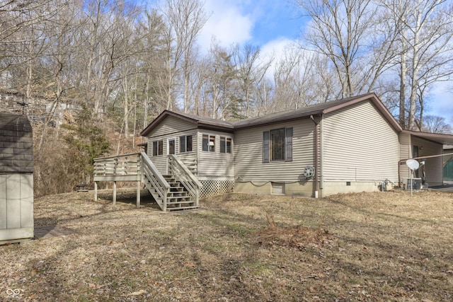 rear view of property with crawl space, a deck, and stairs