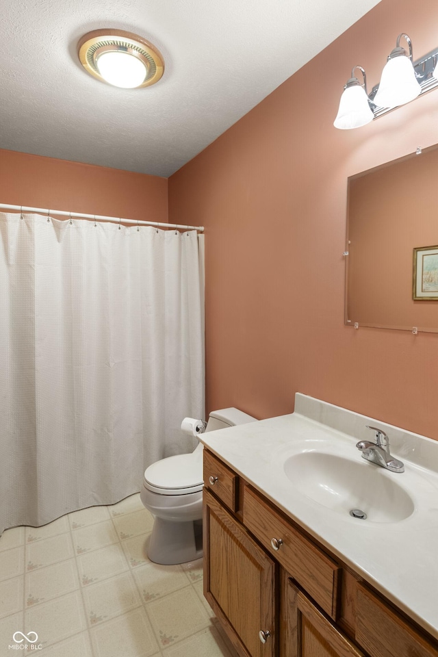 bathroom featuring toilet, tile patterned floors, curtained shower, and vanity