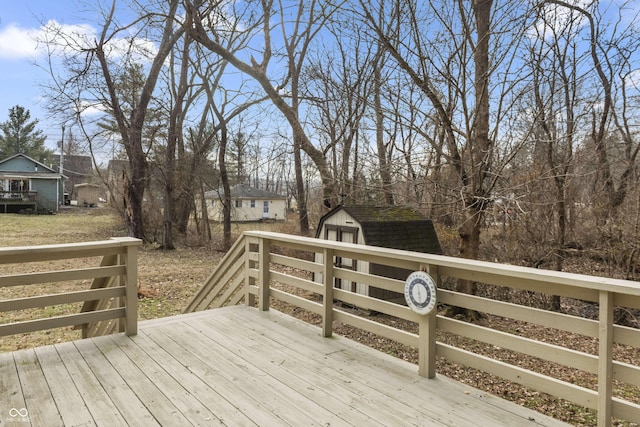 wooden terrace featuring an outbuilding and a shed