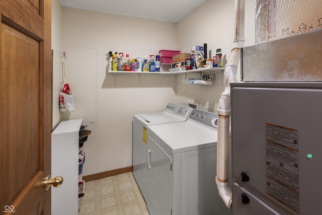 laundry room featuring light floors, laundry area, baseboards, and washing machine and clothes dryer