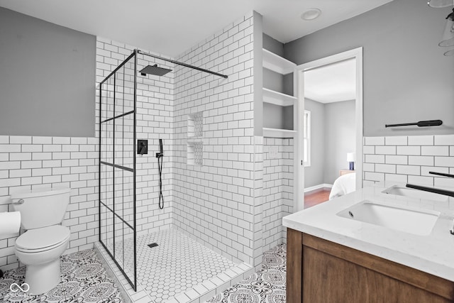 bathroom with tile walls, toilet, a shower stall, ensuite bath, and tile patterned floors