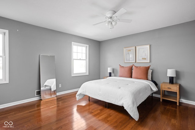 bedroom featuring wood finished floors, a ceiling fan, and baseboards