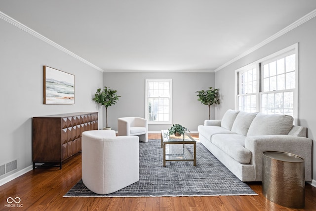 living area with wood finished floors, visible vents, and crown molding