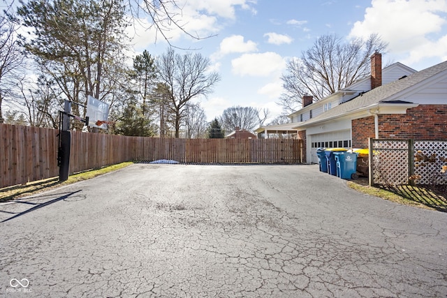 view of street featuring driveway and a gate