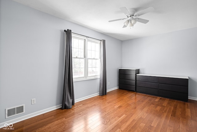 unfurnished bedroom with visible vents, baseboards, and wood finished floors