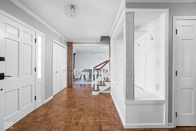 entryway featuring baseboards, an inviting chandelier, and crown molding