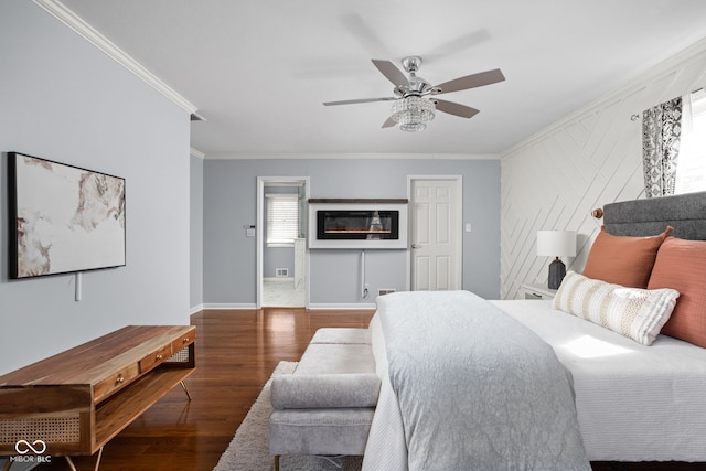 bedroom featuring ornamental molding, a ceiling fan, baseboards, and wood finished floors