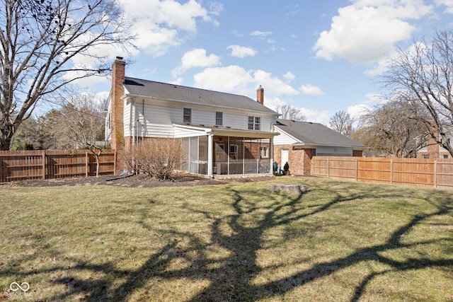 back of house with a sunroom, a fenced backyard, a chimney, and a yard