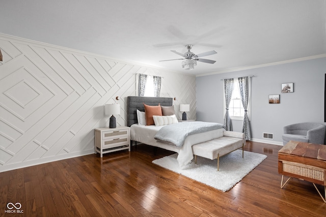 bedroom featuring dark wood-type flooring, a ceiling fan, baseboards, visible vents, and crown molding