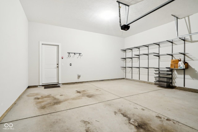 garage featuring a garage door opener and baseboards