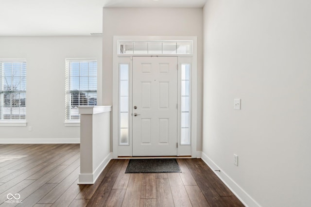 foyer entrance featuring dark wood-style floors and baseboards