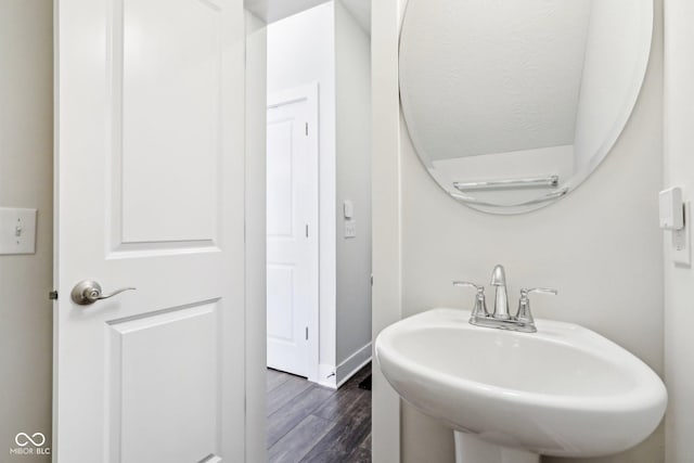 bathroom with a sink, baseboards, and wood finished floors