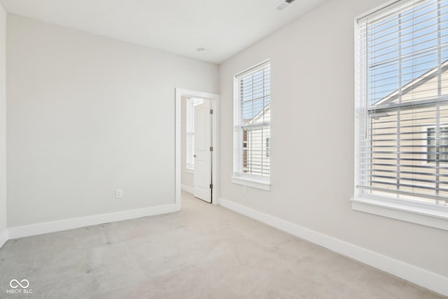 unfurnished room featuring baseboards and light colored carpet