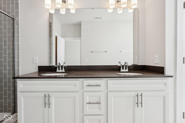 bathroom with double vanity, visible vents, and a sink