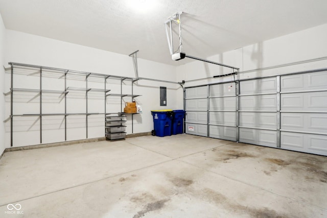 garage with a garage door opener and electric panel