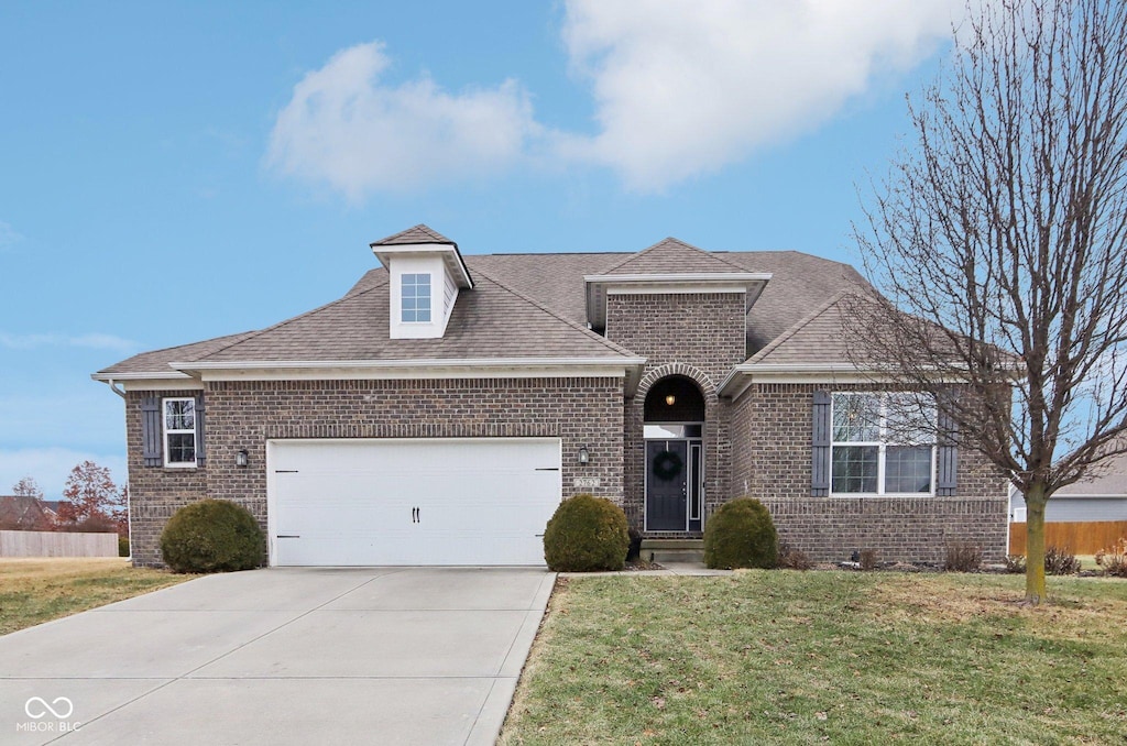 view of front of home with a garage and a front lawn