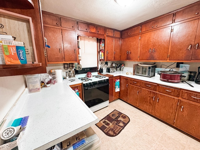 kitchen with a textured ceiling and gas range oven