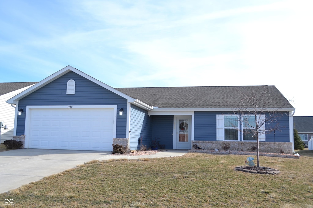 ranch-style home with a garage and a front lawn