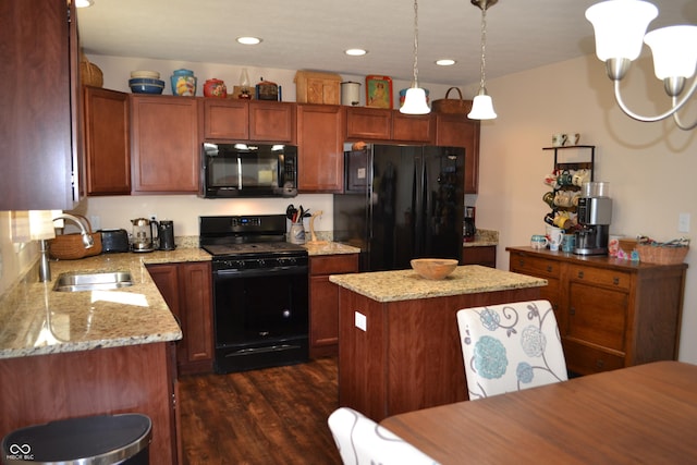 kitchen featuring dark wood-type flooring, sink, a kitchen island, pendant lighting, and black appliances