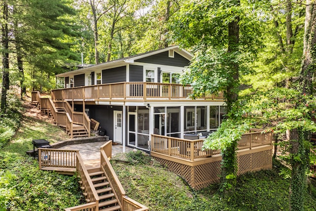 rear view of property with a wooden deck and a sunroom