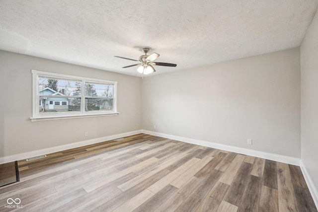 empty room featuring hardwood / wood-style flooring, a textured ceiling, and ceiling fan