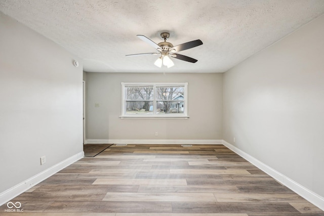 unfurnished room featuring ceiling fan, hardwood / wood-style floors, and a textured ceiling