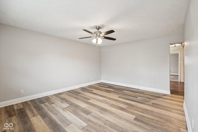 empty room featuring hardwood / wood-style floors, a textured ceiling, and ceiling fan