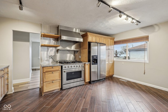 kitchen featuring wall chimney range hood, dark wood-type flooring, stainless steel appliances, light stone countertops, and a textured ceiling